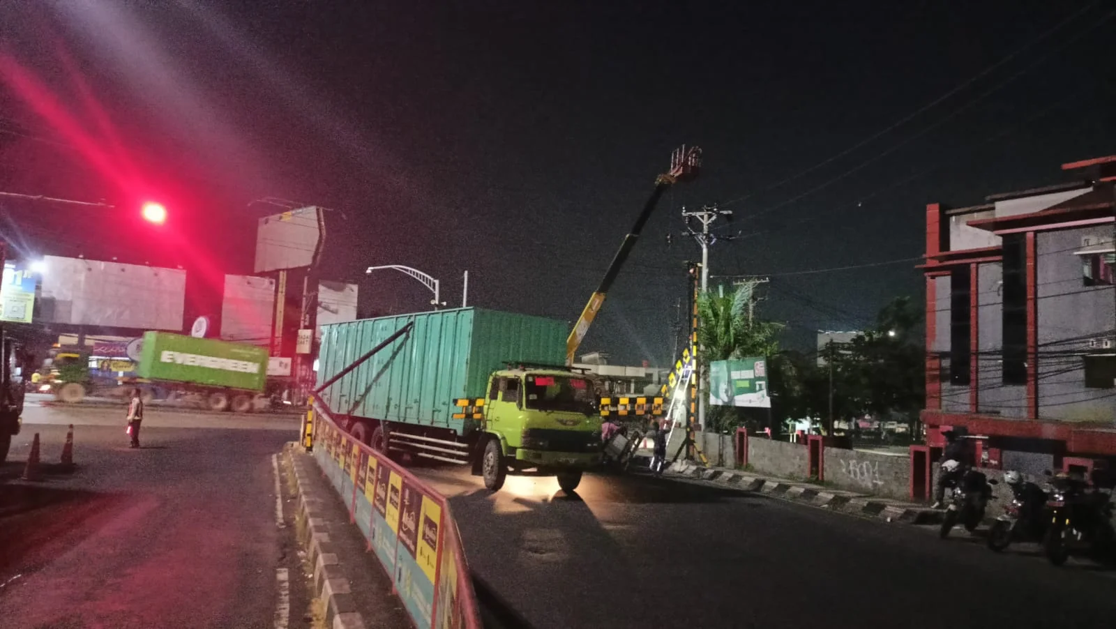 Truk tronton berwarna hijau dengan nomor polisi DK 8172 WQ tabrak portal pembatas kendaraan di kawasan Simpang Jrakah, Jalan Prof. Hamka, Kota Semarang.
