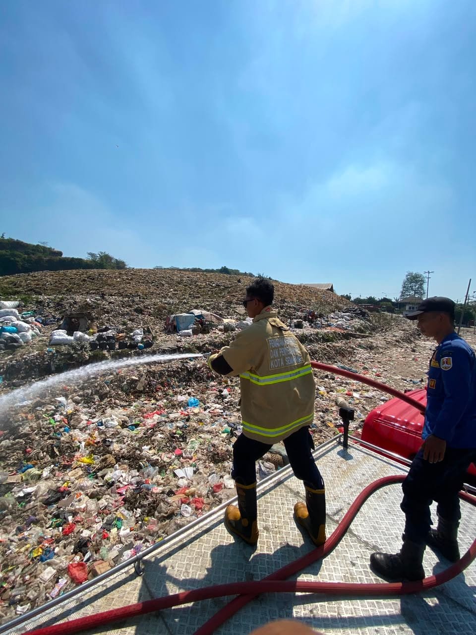 Petugas Damkar dan DLH Semarang semprotkan air dinginkan tumpukan sampah di TPA Jatibarang.