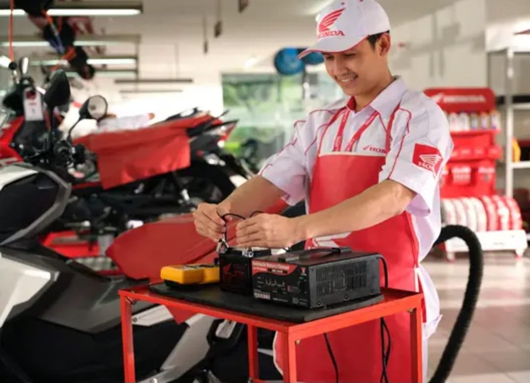 Mekanik AHASS memeriksa kondisi tegangan aki motor injeksi Honda.